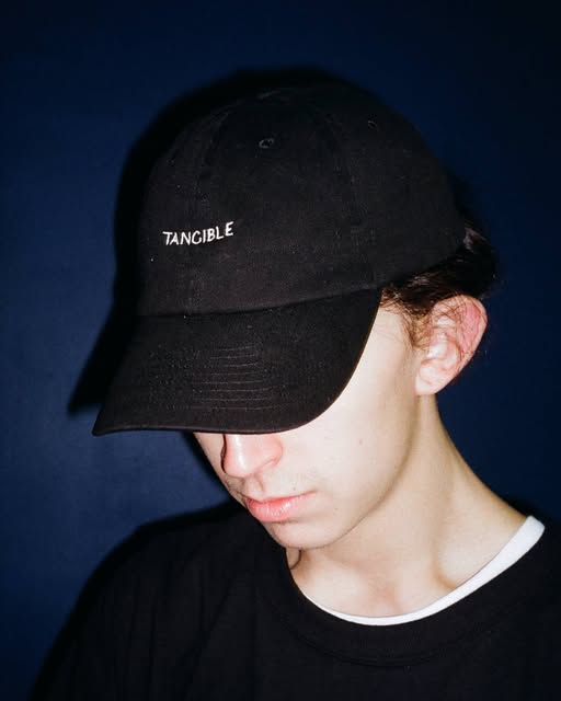Direct-flash portrait in a dark cap